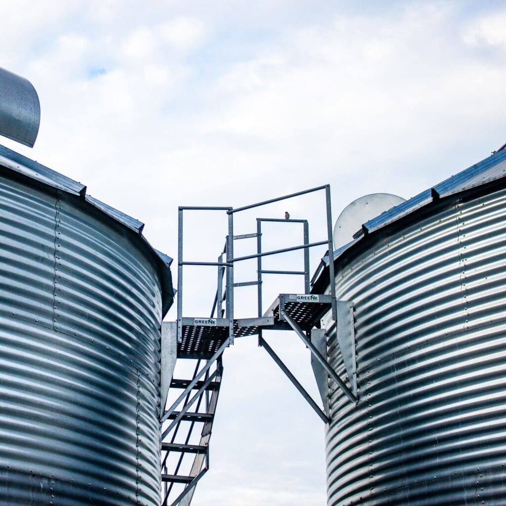 Low angle shot of huge steel storage tanks in the industrial zone against a cloudy sky