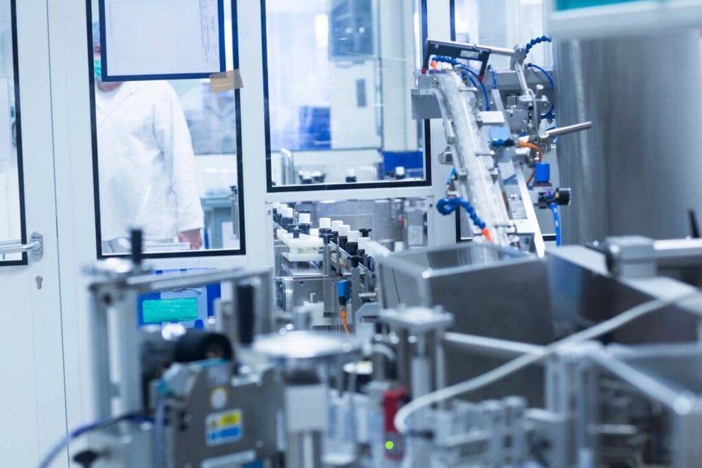 Machine sorting bottles on production line in pharmaceutical plant