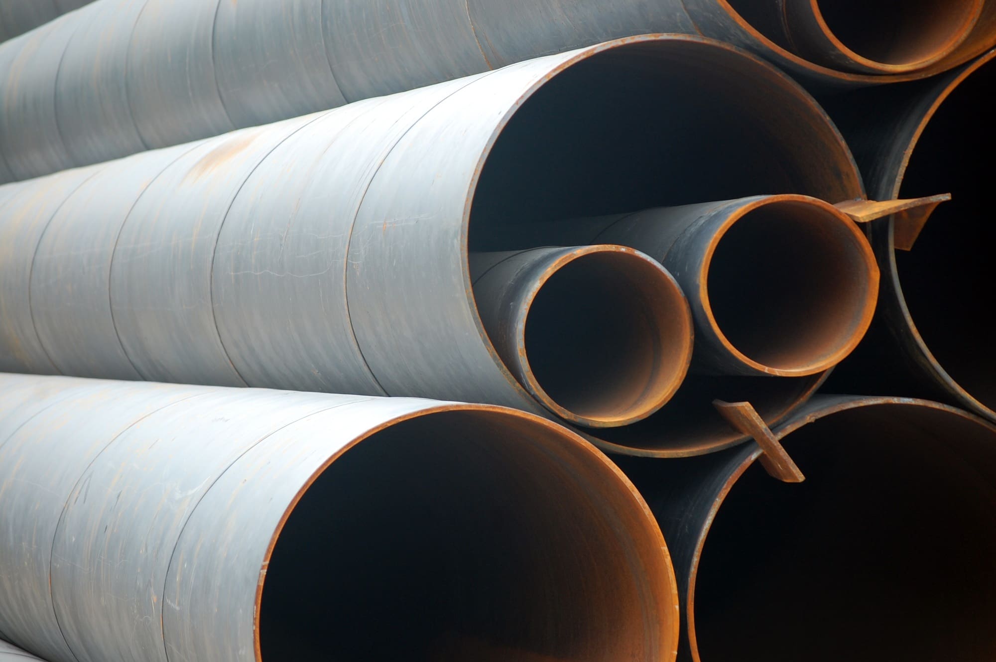 Closeup of rusty steel casing pipes under a white light