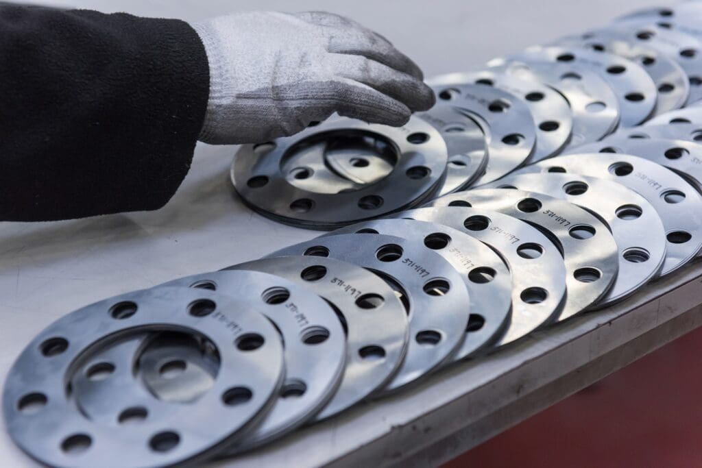 Engineers hand arranging cut parts in engineering factory, close up